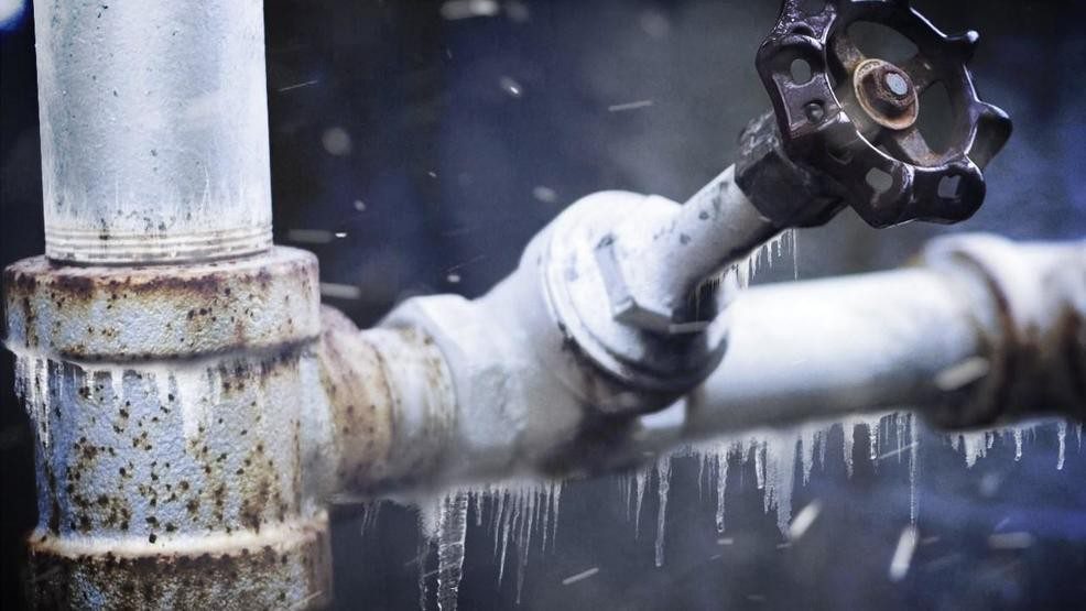 Frozen outdoor water pipe with rust and ice buildup, showing potential risk of burst pipes during winter weather.